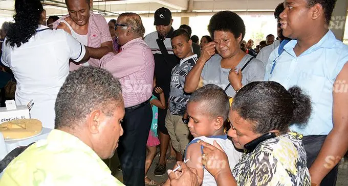 Suva Medical Centre medical staff (left) assist Alitia Ragele and her seven-year-old son Seveci Ravetau with free measles vaccination. Photo: Ronald Kumar