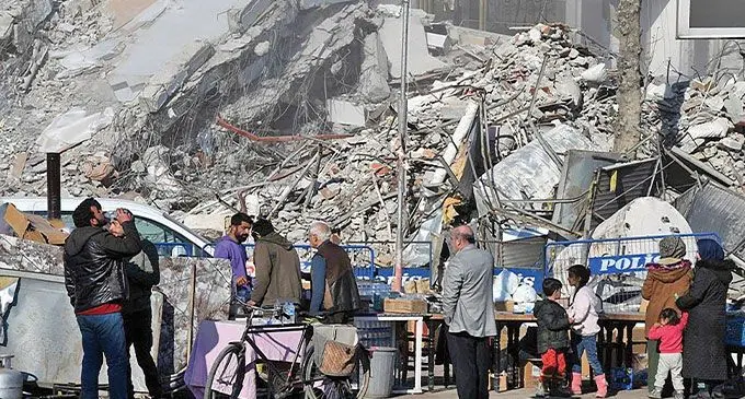 People are seen near the rubble of a destroyed building in the quake-hit city of Adiyaman, Turkiye, on February 20, 2023. Photo: Xinhua 