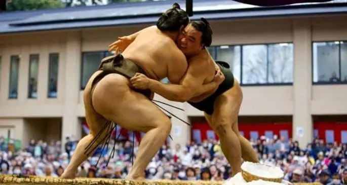 Mongolian-born grand sumo champion Hakuho (L) and Harumajuji compete during a show fight at the "Honozumo", a ceremonial sumo tournament, at the Yasukuni Shrine in Tokyo, on April 3, 2015. (Xinhua)