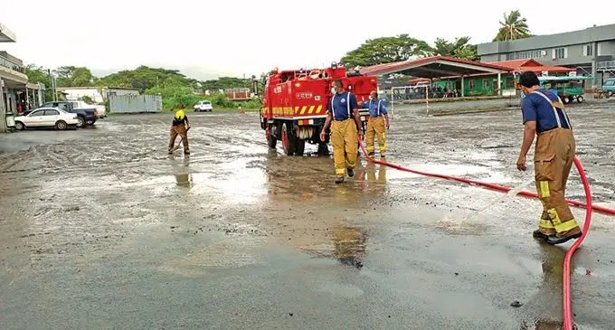 National Fire Authority officers clearing silt and mud in Rakiraki Town on January  11,2022. Photo: Salote Qalubau 