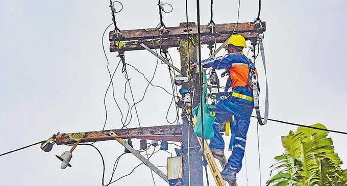 An EFL worker works on a power post
