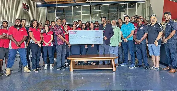 Al-Hamd Smart Living , General manager Anilesh Kumar receives $10,000 from managing director Ashfaaq Khan for team bonding and well being of staff activities. Photo: Charles Chambers