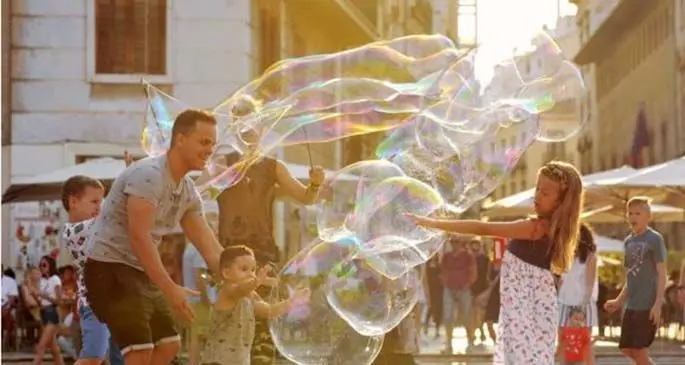 Children play with soap bubbles at a square in Valencia, Spain, July 14, 2019. (Xinhua/Guo Qiuda)