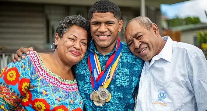 Queen Victoria School headboy Tomasi Seru is flanked by his parents Mere and Tomasi Seru (snr) at their Davuilevu Housing home on August 21, 2022. Photo: Leon Lord