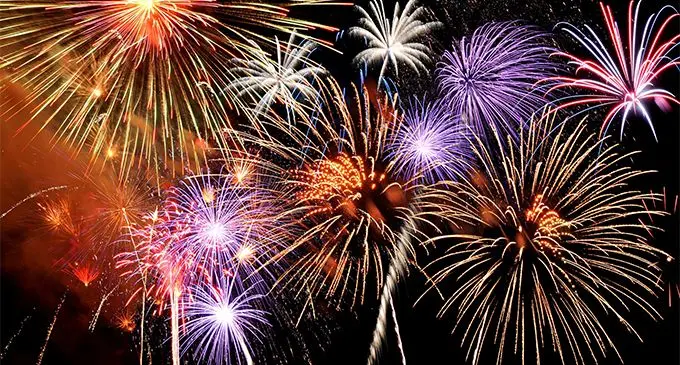 Fireworks of various colors bursting against a black background