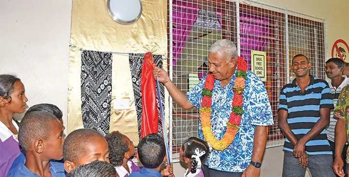 Prime Minister Voreqe Bainimarama is assisted by students of Namau Public School at the commissioning of the Grid Extension Project at Namau Public School on January 29, 2019. Photo: DEPTFO News
