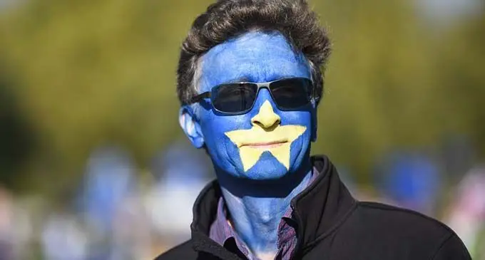 A protester with his face painted in the colors of an EU flag prepares to attend the "Together for the Final Say" event at the Parliament Square in London, Britain, on Oct. 19, 2019. (Photo by Stephen Chung/Xinhua)
