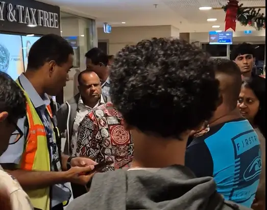 Passengers speak to a ground-crew 