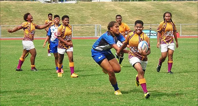 2018 Jasper Williams High School Under-17 player Merewati Qolo tries to evade the Cuvu College defence during the Fiji Secondary Schools Rugby Union Western division schoolgirls final at Churchill Park, Lautoka on July 14, 2018.