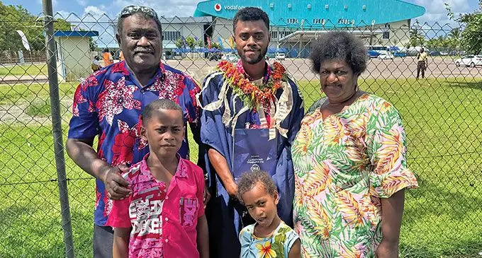 Semi Seruvakula (in garland), with his proud family members after the graduation on December 12, 2024. Photo: Asenaca Ratu