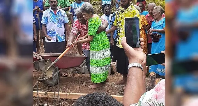 Sulio Bulinadi assists 80-year-old Asela Sucu during the traditional ceremony of laying down the housepost of the evacuation centre at Vuya Village in Bua.