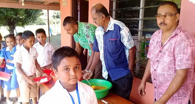 Ashwin Lal (right) and his friends feeding the students of Wairuku Primary School, Rakiraki