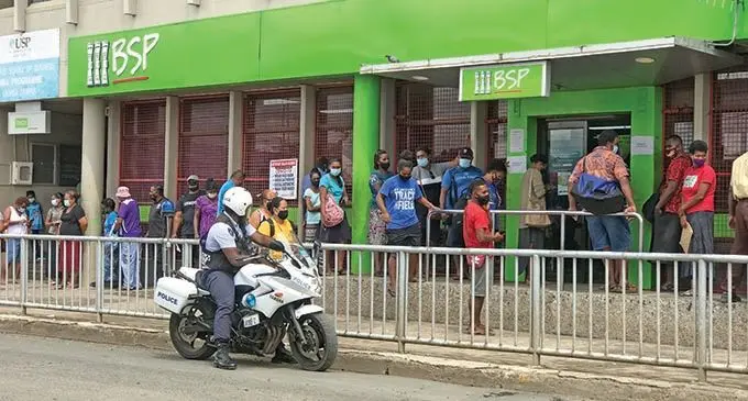 A police officer on patrol advises the public to maintain physical distancing outside the Bank South Pacific branch in Labasa on September 2, 2021.   Photo: Shratika Naidu