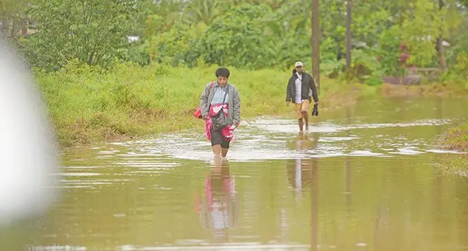 Nabukavesi villagers crossing through the flooded road to get to the Queens Highway on April 26, 2022. Photo: Ronald Kumar
