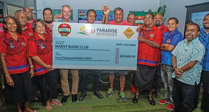 The Marist 7’s committee receives the cheque from Paradise Beverages general manager Mike Spencer (sixth from left) on January 12, 2023. Photo: Leon Lord