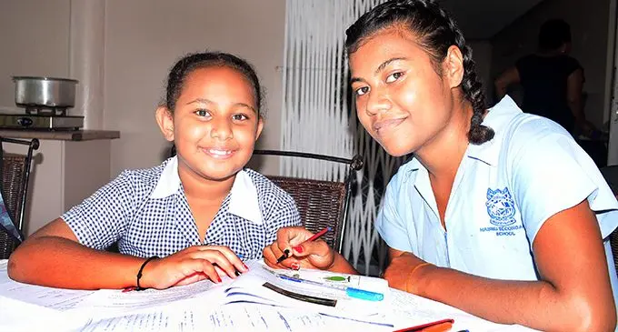 Elizabeth Qaqaturaga 10, a year 5 students at CMF primary school and with her cousin sister, Meresaini Serau 18, a year 13 student at Nasinu Secondary School doing home study in their school uniform and following school timetable at home on April 22, 2020. Photo: Ronald Kumar.