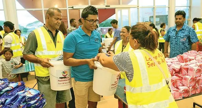 Fijian Competition and Consumer Commission Chief Executive Officer Joel Abraham (second from left)with members of the Sai Prema Foundation and volunteers packing the buckets of Love. Photo: Leon Lord