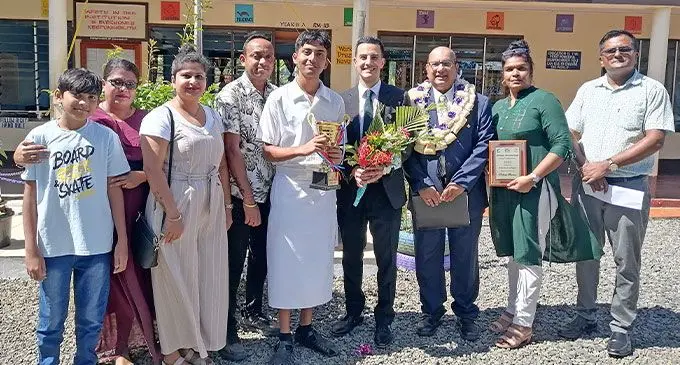 Adran Kumar holds his trophy alongside New Zealand Deputy High Commissioner Alex Shahryar-Davies, Dr Satendra Singh (standing to his right), teachers, and family. at Sabeto College in Nadi. Photo: Mereleki Nai