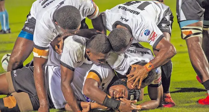 Nadroga first five eight Peni Kadralevu (wearing headgear) is mobbed by his team-mates after scoring a try against Suva on April 10, 2021. Photo: Leon Lord