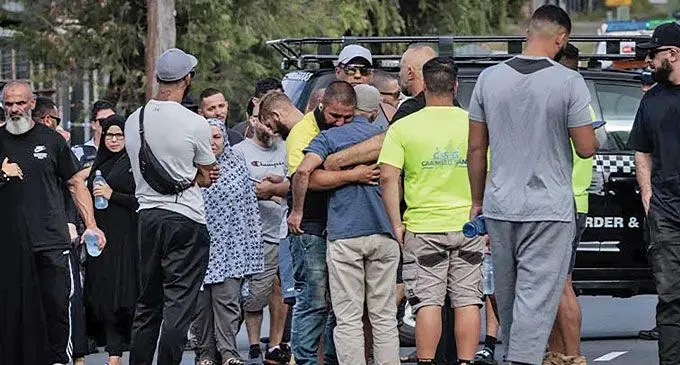 Locals gather at the scene of the shooting outside the Elite Fight Force martial arts gym in Carlingford Street, Sefton, on Thursday morning.