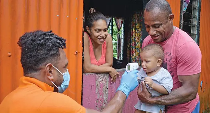 Joeli Colati of the Ministry of Health (left) screens one year-old Zabata Zaula with relatives  Seremaia Koroi and Ema Tiko at Nadonomai Settlment during the Ministry of Health COVID-19 mobile clinic in Lami on April 22, 2020. Photo: Ronald Kumar