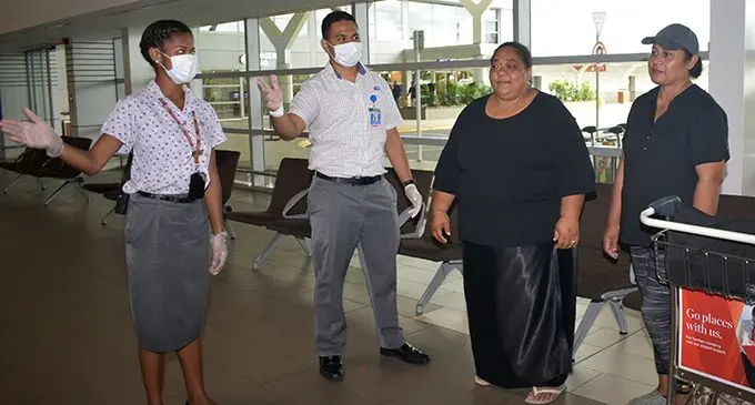 From left to right; Air Terminal Services staff Reama Cakau, Wilson Erasito with travellers at the Nadi International Airport. Photo: Mereleki Nai