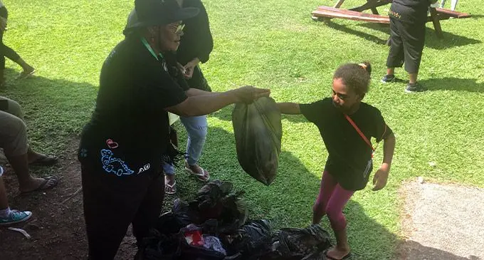 USP Educare Centre Head Teacher, Vaciseva Rarako receives a bag of rubbish from one of her students.