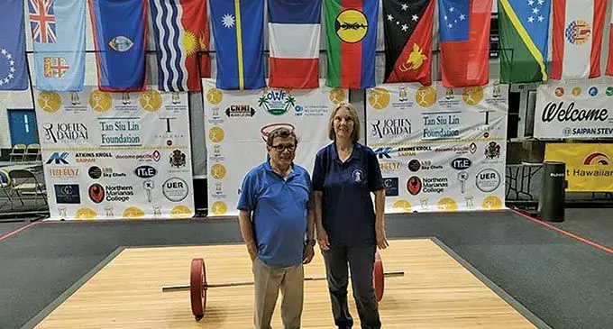 From left: Oceania Weightlifting Federation general secretary Paul Coffa and CNMI Weightlifting general secretary Jeanne Rayphand pose for a photo in the weightlifting venue of the 2022 Pacific Mini Games at the MHS gym on June 13, 2022. Photo : Marianas Variety 