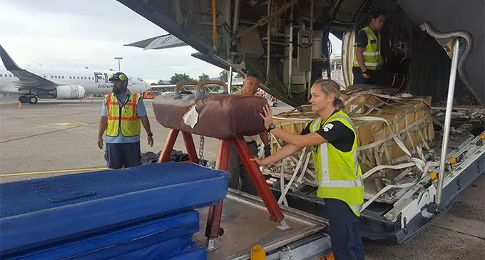  Air Loadmaster Flight Sergeant Destry Tumataiki (centre) and Logistics Specialist Leading Aircraftman Frankie-Lee Murray-Birch (right), from the Royal New Zealand Air Force’s No.40 Squadron, help offload half a tonne of gym equipment donated by the Christchurch School of Gymnastics to the Gymnastics Federation of Fiji.