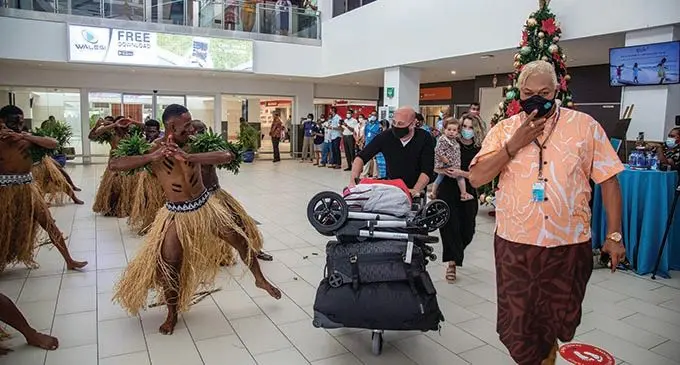 Fiji Airports Limited Manager Airport Landside Operations and Customer Services Joe Gray helps escort the country’s first of many foreign tourists from Sydney, Australia, who arrived at the Nadi International Airports on December 1, 2021, after almost two years of border closure.  Photo: Leon Lord