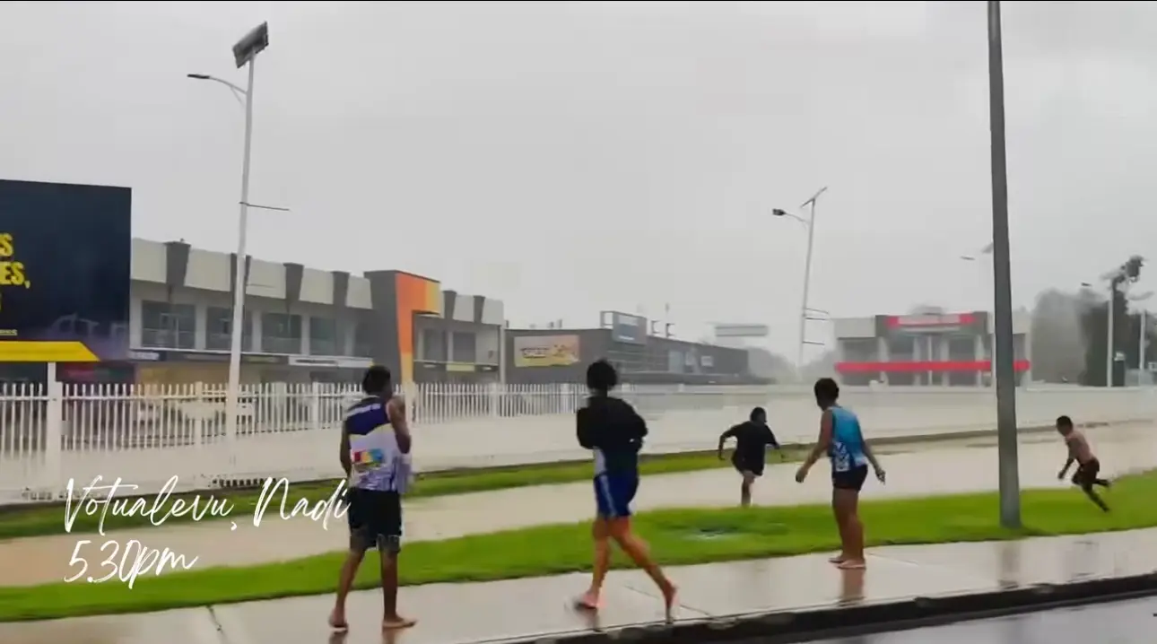 Children jumping into a flooded drain in Votulevu, Nadi.