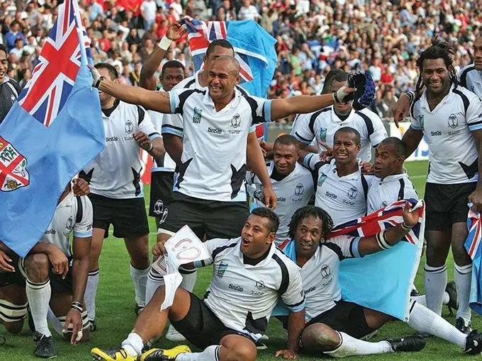 Members of the Flying Fijians 2007 Rugby World Cup team that beat Wales in the pool stages to advance to the quarterfinal stages. Sitting (from left) are Sunia Koto and Vilimoni Delasau; kneeling are (from left) Norman Ligairi, Seremaia Bai and Jone Daunivucu. Standing are Vereniki Sauturaga (back holding Fiji flag), Aca Ratuva (front with flag), the late Seru Rabeni (second from right) and Semisi Naevo.