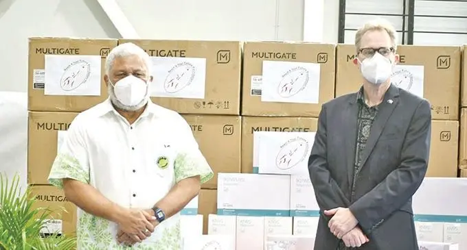 Prime Minister Voreqe Bainimarama with Australian Deputy High Commissioner to Fiji Paul Wilson standing in front of the boxes containing the masks donated by Australia-based Fijian charity group, Reach for Future Foundation.