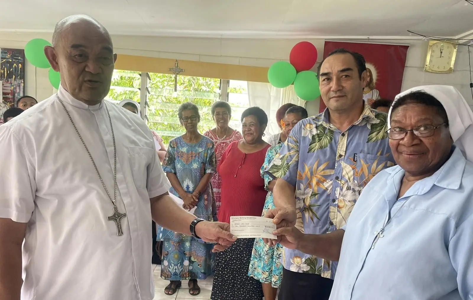 From left: Archbishop Peter Loy Chong hands over the $10,000 cheque to Father Law Home representatives, manager Joeli Moceivale and Sister Rosa Domowai in Wailekutu, Lami, on December 23, 2025.