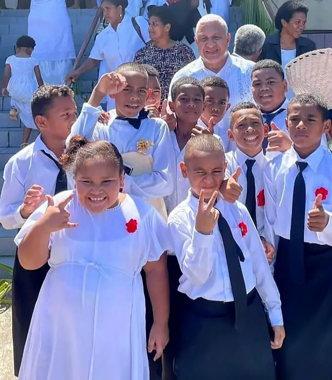 Prime Minister Voreqe Bainimarama with the children of Saioni Vou Methodist Church, the same church where he has celebrated Palm Sunday for the past 18 years. Photo: Office of the Prime Minister
