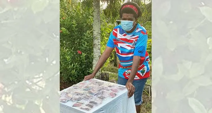 Emele Tamani, a committee member for MA Khan Road in Nawaka i Nadi waits for residnets to pick up vegetable seeds given by the Ministry of Agriculture.