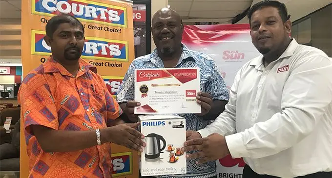 Courts retail manager Benjamin Mohammed (left), and Fiji Sun  marketing manager Rajiv Raju (right) present the letter of the week award for December 2017 to Tomasi Boginiso on March 27, 2018.  Photo: Sheldon Chanel
