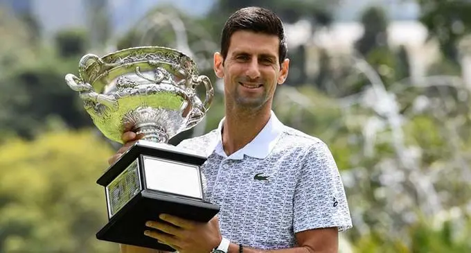 Australian Open men's singles champion Novak Djokovic of Serbia poses for photographs with the winner's trophy at Royal Botanic Gardens Victoria in Melbourne, Australia on Feb. 3, 2020. (Photo by Bai Xue/Xinhua)
