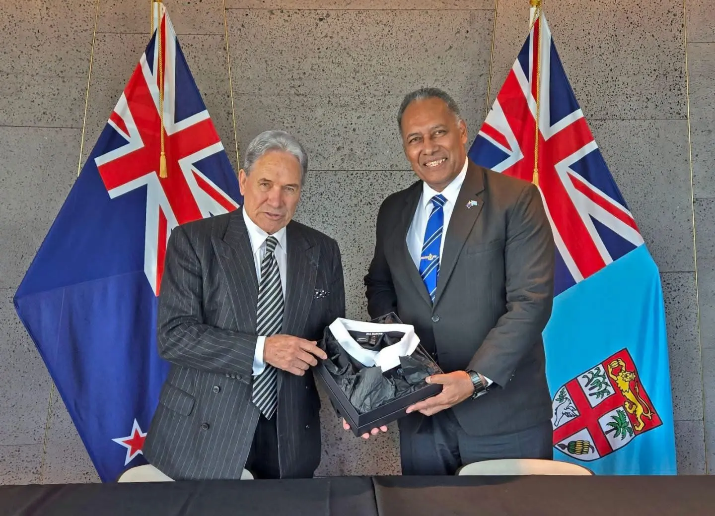 Minister for Foreign Affairs and External Trade, Hon. Sakiasi Ditoka presents a token of appreciation to the Minister of Foreign Affairs of New Zealand, Hon. Winston Peters following the official signing ceremony.