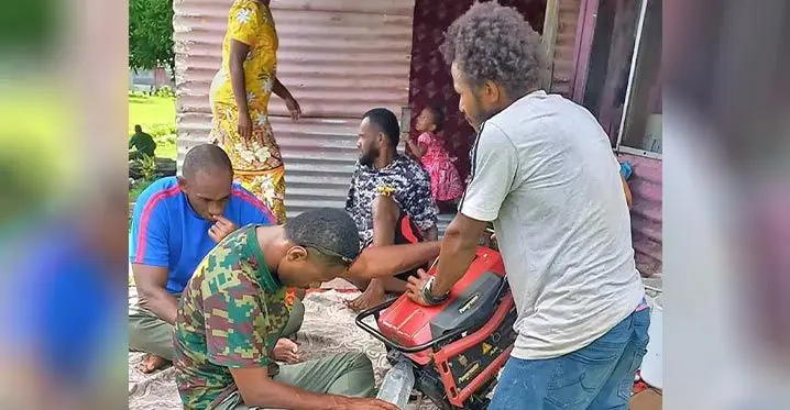 Waisale Digitaki (in grey T-shirt) watches his generator get fixed on February 24, 2023. Photo: Josefa Babitu