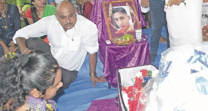 Ravin Roy Chand (left) during the funeral of his 15 year-old son, Rayshal Roy who drowned during a family picnic. Photo: Ronald Kumar