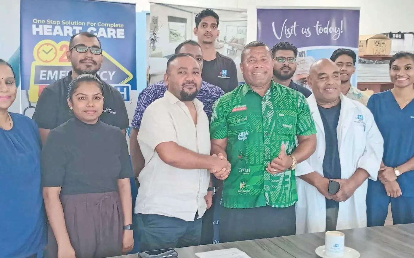 Pacific Specialist Healthcare (PSH) Hospital founder and chief executive officer Parvish Kumar shakes hands with rugby legend Waisale Serevi, surrounded by staff of the PSH Hospital. Photo: Charles Chambers