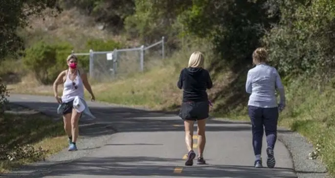 People walk along a trail at a park in San Mateo County, San Francisco Bay Area, the United States, May 4, 2020. (Photo by Li Jianguo/Xinhua)