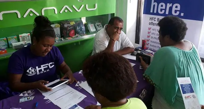 Diaqela Likusiga (Valuefone Staff) and Bimal Jagrup (HFC Bank Business Relationship Officer) serving customers at the e-lavo road show at Rakiraki Town. Photo: HFC