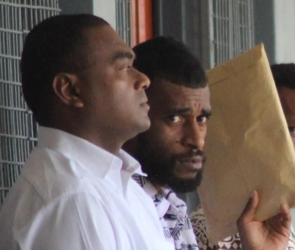 Sekove Asama (second from left) sits beside a police officer outside the Labasa Courthouse on February 10, 2025.