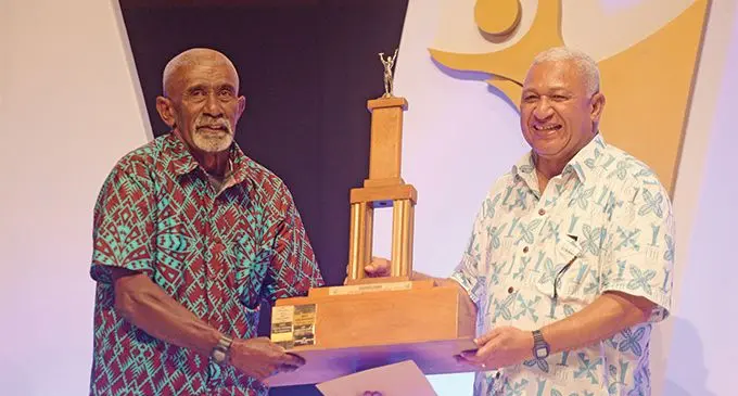 Jolame Turaganiqali, 61, receives the Fiji Sports Council 2018 Sportsman of the Year award on behalf of his son Alivereti Veitokani from Prime Minister Voreqe Bainimarama at the FMF Gymnasium, Suva on March 1, 2019. Photo: Ronald Kumar. 