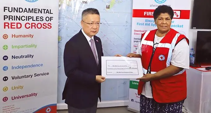 Chinese Ambassador Qian Bo hands over the cheque to Ilisapeci Rokotunidau, Director-General of the Fiji Red Cross Society. Photo: Supplied 