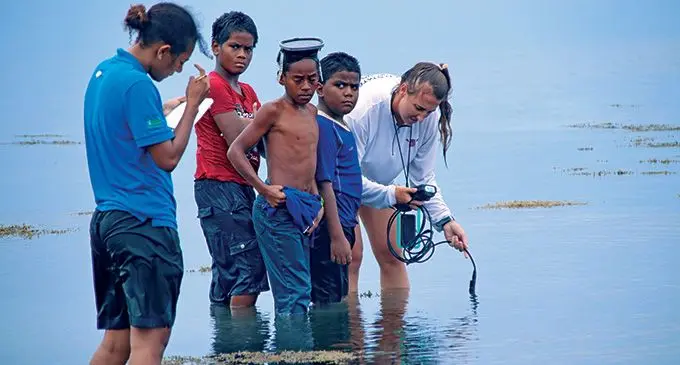 Seagrass researcher Carrie Wentzel with Marine Scientist Susana Tauyavuca being assisted by a few children of Waiqori village, Oneata on March 19, 2022. Photo:Kelera Sovasiga
