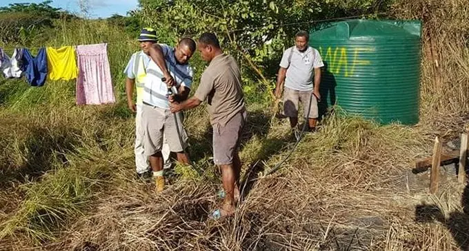 The Water Authority of Fiji employees installing the new water tank for Atelaite Koto and her two sons this afternoon. Photo: Moses Brown 
