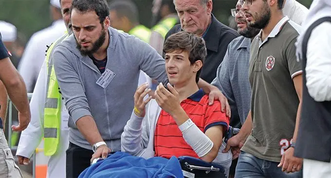 Zaed Mustafa, in wheelchair, brother of Hamza and son of Khalid Mustafa who were killed in the Friday, March 15 mosque shooting, during their burial at the Memorial Park Cemetery in Christchurch, on New Zealand, Wednesday, March 20, 2019.  